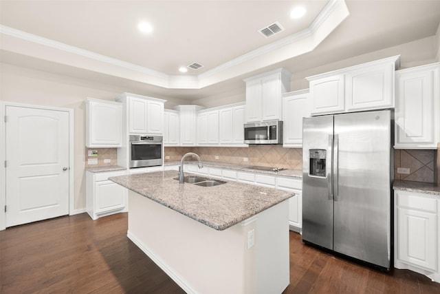 kitchen featuring appliances with stainless steel finishes, sink, white cabinets, and a tray ceiling