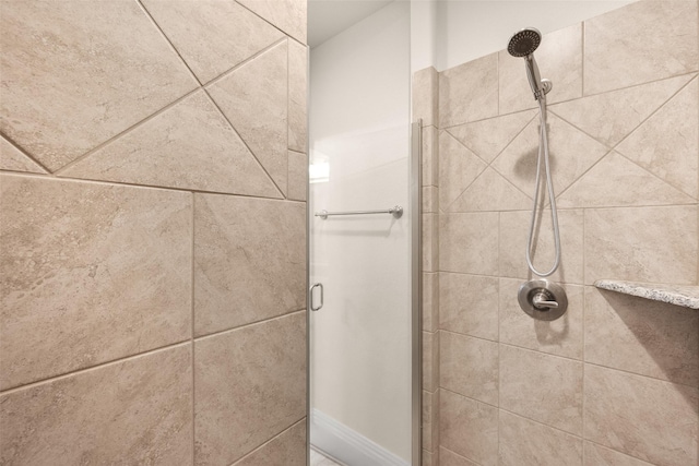 bathroom featuring a shower with shower door