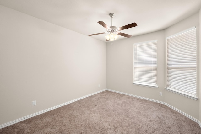 carpeted spare room featuring ceiling fan