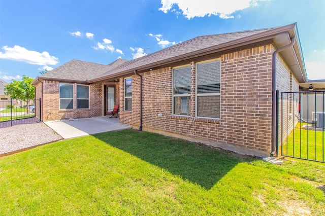 rear view of property with a lawn and a patio