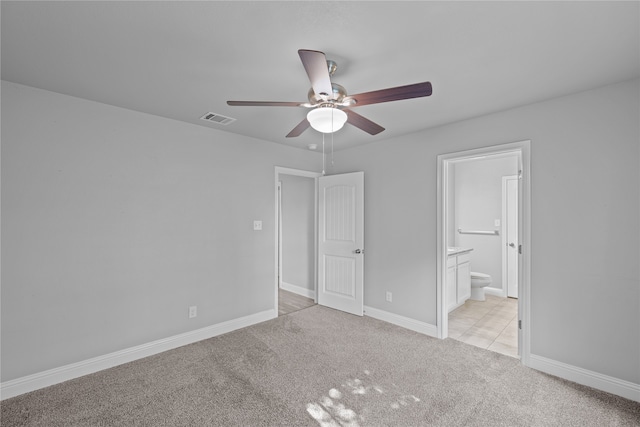 unfurnished bedroom with ceiling fan, ensuite bathroom, and light colored carpet