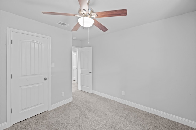 unfurnished bedroom featuring light carpet, a closet, and ceiling fan