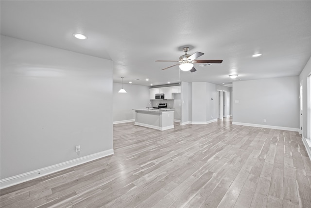 unfurnished living room featuring ceiling fan and light hardwood / wood-style flooring