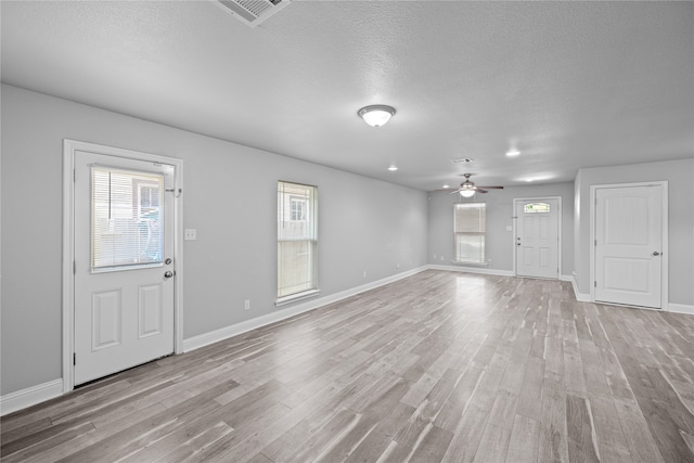 foyer entrance with ceiling fan, a textured ceiling, and light wood-type flooring