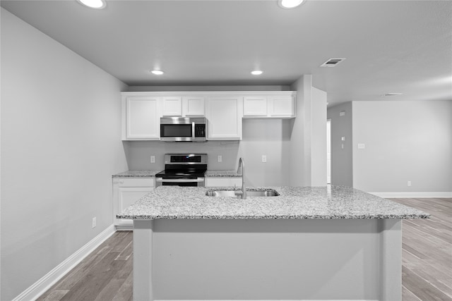 kitchen with white cabinets, an island with sink, stainless steel appliances, and sink