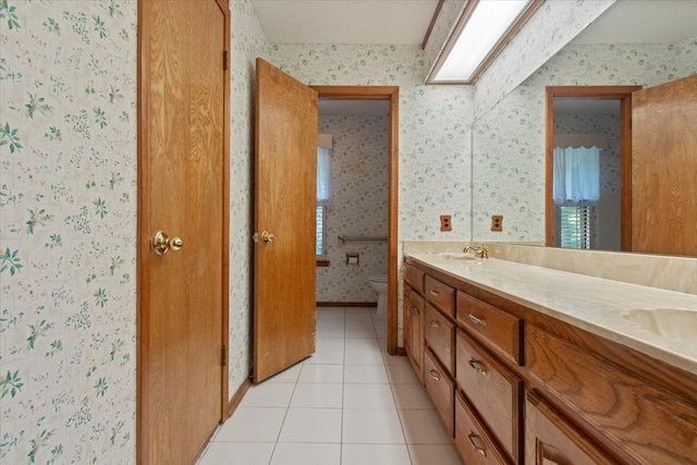 full bath with wallpapered walls, toilet, double vanity, tile patterned floors, and a sink