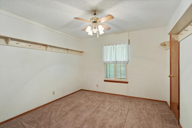 carpeted empty room featuring a ceiling fan, baseboards, and a textured ceiling