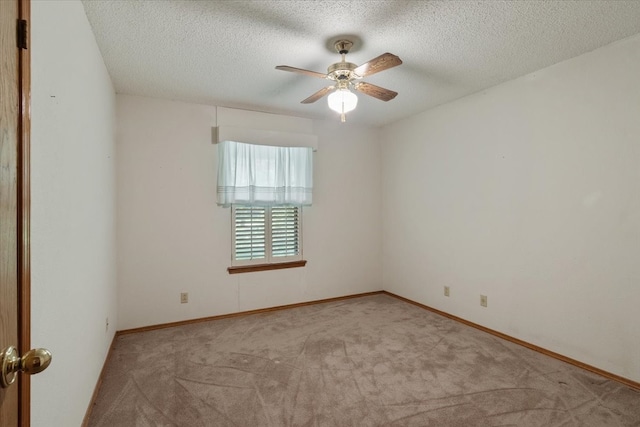 carpeted empty room featuring baseboards, a textured ceiling, and a ceiling fan