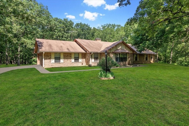 single story home featuring a front lawn, brick siding, driveway, and a chimney