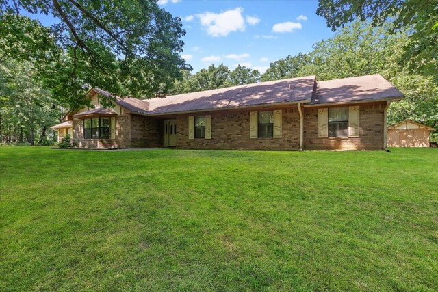 rear view of property with a lawn and brick siding