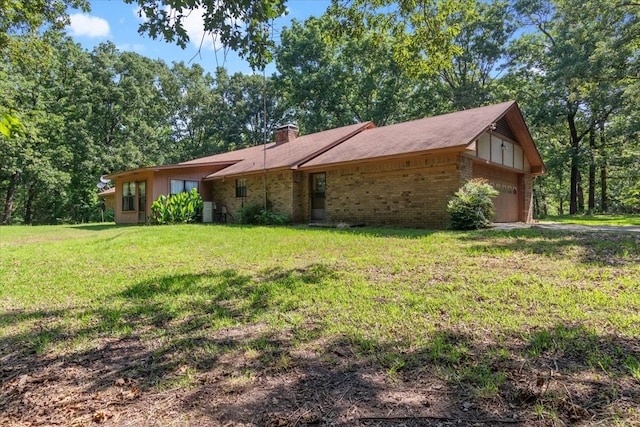 view of front of property featuring a chimney, a front lawn, a garage, central air condition unit, and brick siding