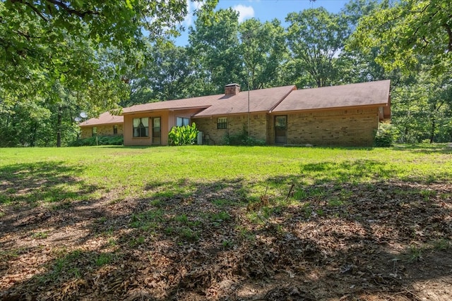 view of front of home with a chimney and a front lawn