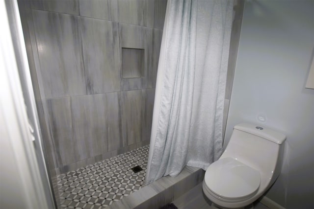 bathroom featuring curtained shower and toilet