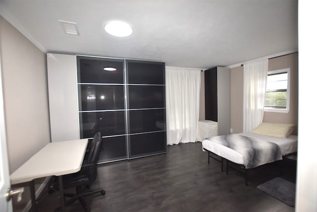 bedroom with crown molding and dark hardwood / wood-style flooring