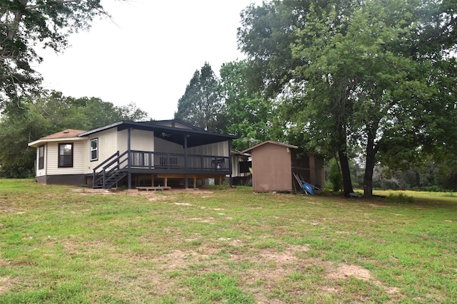 rear view of property with a yard and a storage unit