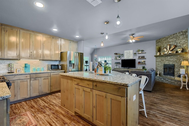 kitchen with dark hardwood / wood-style flooring, pendant lighting, extractor fan, and appliances with stainless steel finishes