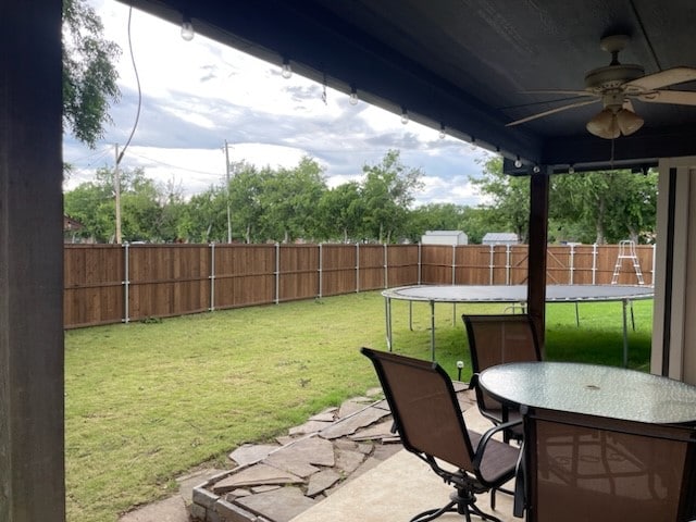 view of yard with ceiling fan, a patio area, and a trampoline