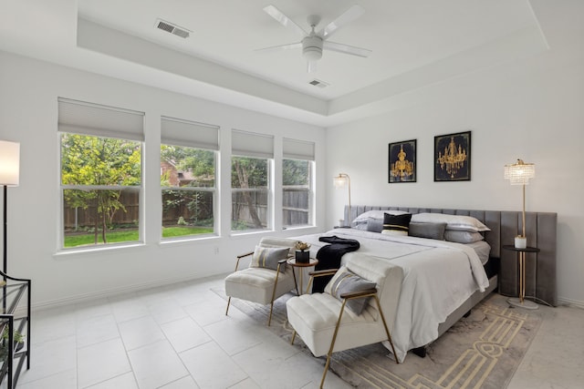 bedroom with light tile patterned flooring, a raised ceiling, and ceiling fan