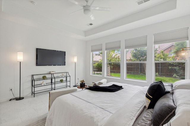 bedroom with a tray ceiling and ceiling fan