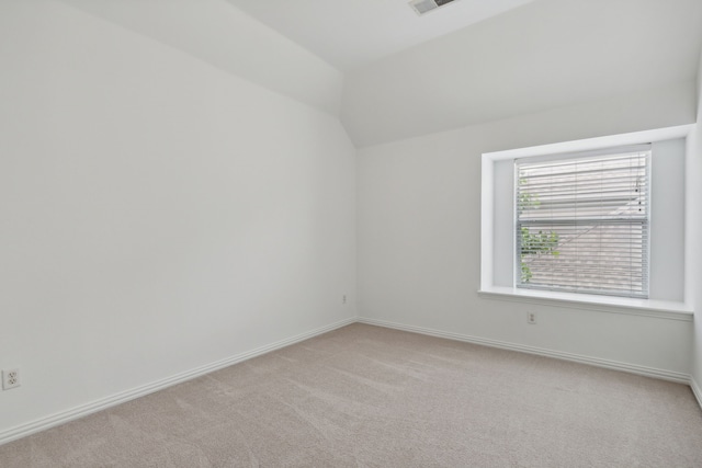 spare room featuring carpet flooring and lofted ceiling