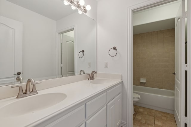 full bathroom featuring dual vanity, toilet, tile patterned floors, and tiled shower / bath combo