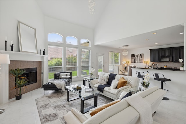 living room with a fireplace and high vaulted ceiling