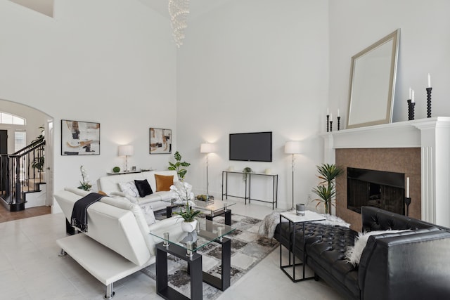 living room featuring tile patterned floors, a tiled fireplace, and a high ceiling