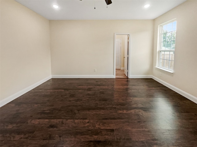 empty room with ceiling fan and dark wood-type flooring