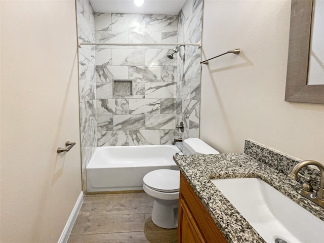 full bathroom featuring hardwood / wood-style flooring, tiled shower / bath combo, vanity, and toilet