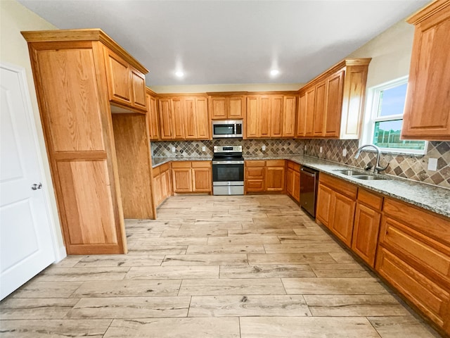 kitchen featuring sink, light hardwood / wood-style floors, backsplash, and appliances with stainless steel finishes