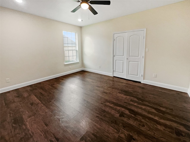 empty room with ceiling fan and dark wood-type flooring