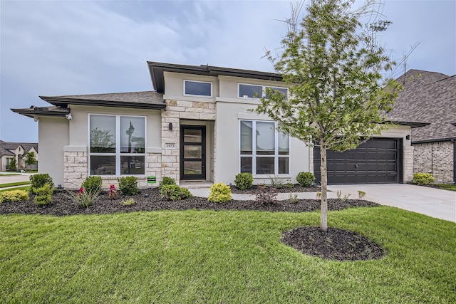 prairie-style home featuring a garage and a front lawn