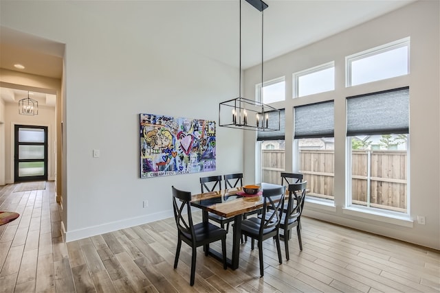 dining space featuring plenty of natural light, light hardwood / wood-style flooring, and an inviting chandelier