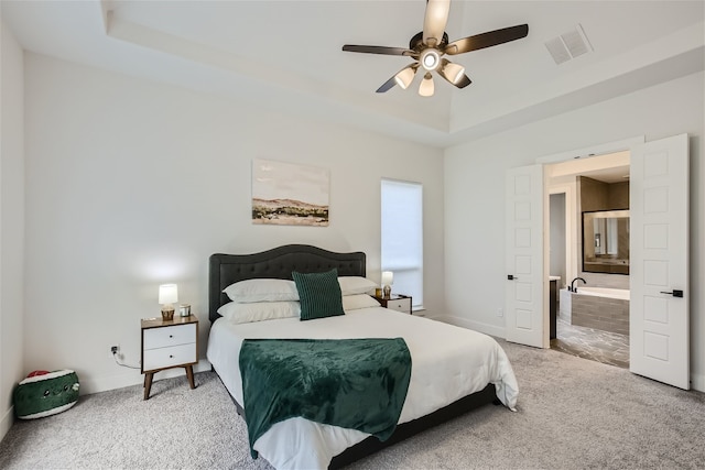 bedroom with light carpet, ceiling fan, and a raised ceiling