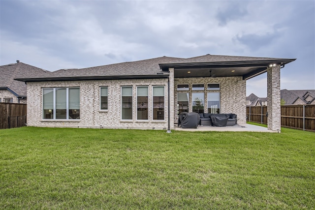 rear view of property featuring a lawn, an outdoor living space, and a patio area