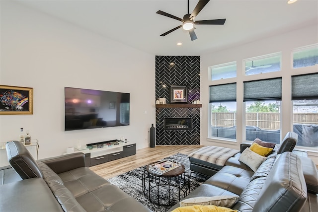 living room with ceiling fan, hardwood / wood-style floors, and a fireplace