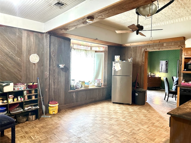 interior space with light parquet floors, ceiling fan, and wooden walls