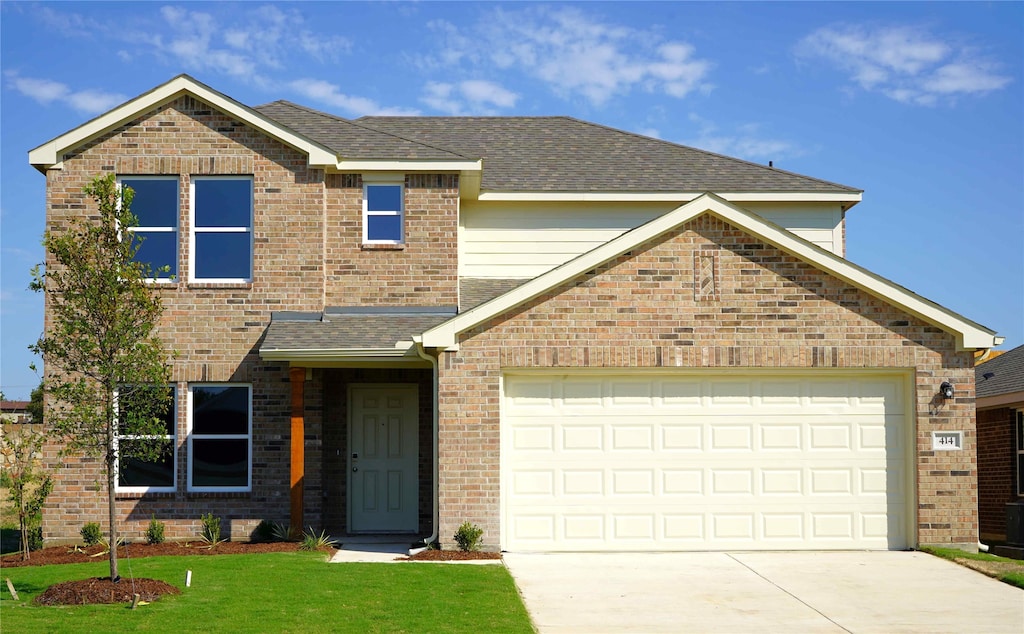 view of front of home with a garage and a front lawn