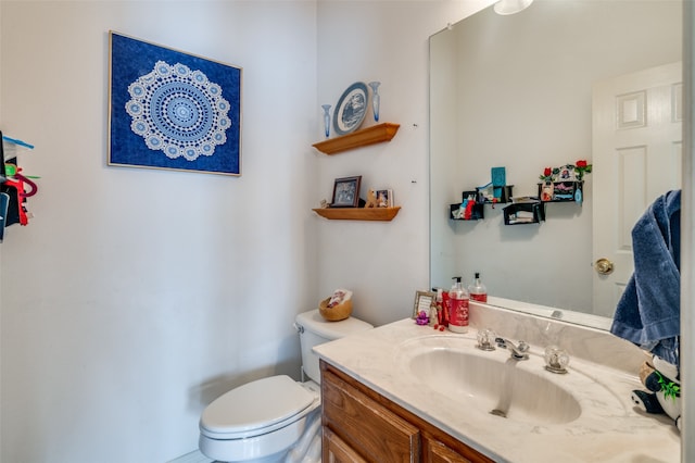 bathroom featuring vanity with extensive cabinet space and toilet