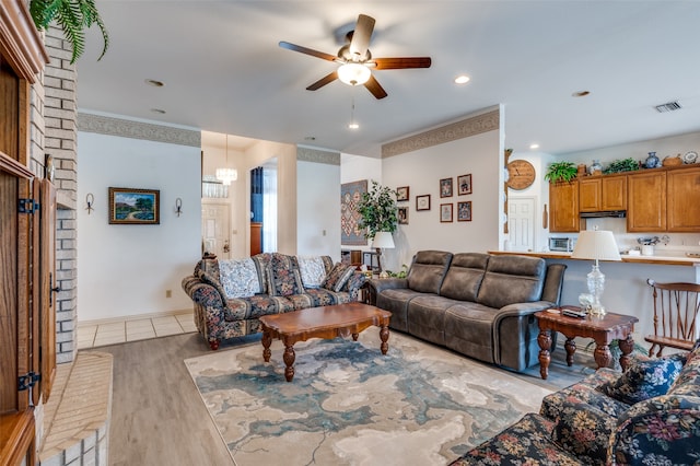 living room featuring brick wall, ceiling fan, and light hardwood / wood-style flooring