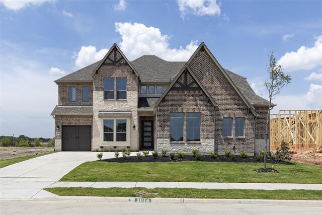 view of front of home with a garage and a front lawn