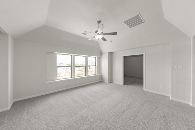 unfurnished bedroom featuring a spacious closet, ceiling fan, lofted ceiling, and light carpet