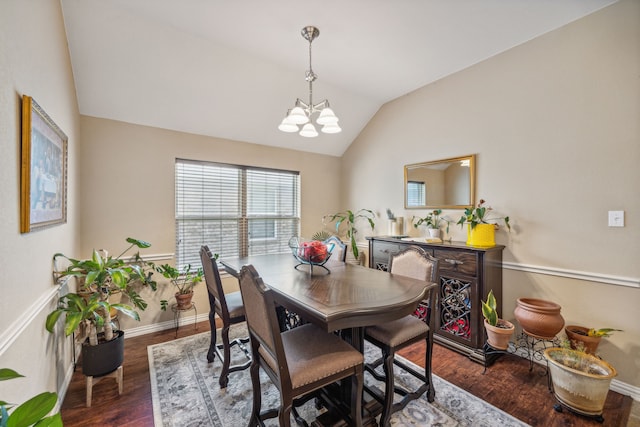 dining room with an inviting chandelier, lofted ceiling, and dark wood-type flooring