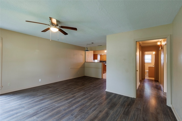 spare room featuring a textured ceiling, dark wood-type flooring, and ceiling fan