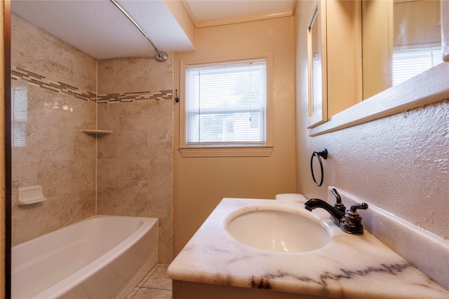 bathroom with tile floors, tiled shower / bath combo, plenty of natural light, and vanity