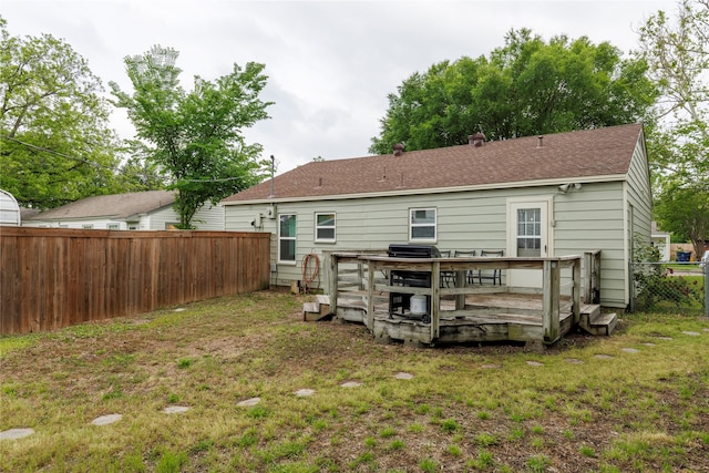 back of house featuring a wooden deck and a yard