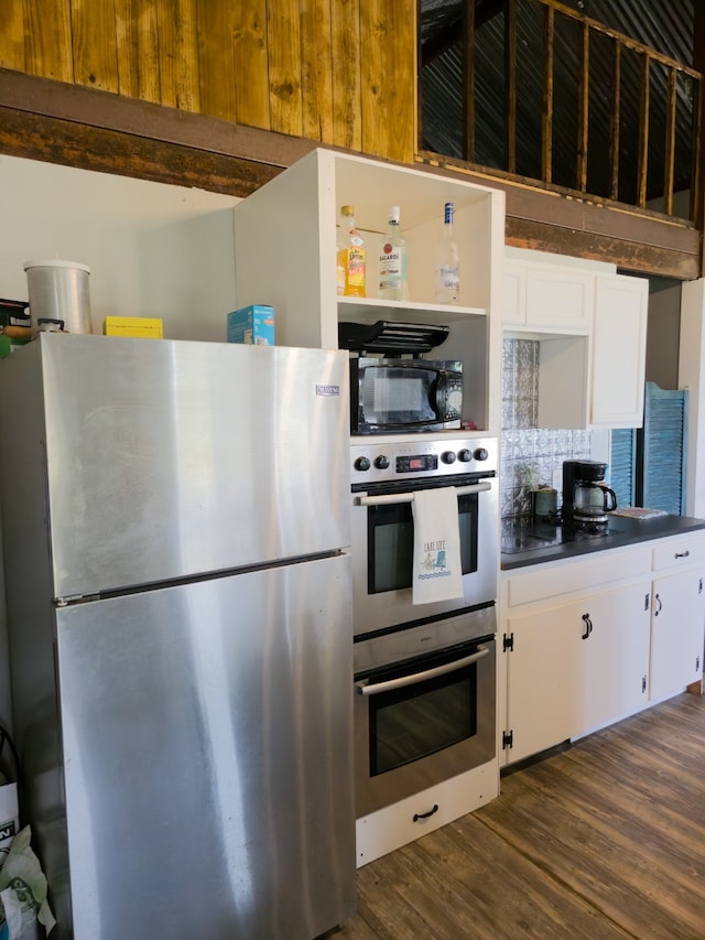 kitchen with white cabinetry, appliances with stainless steel finishes, and dark hardwood / wood-style floors