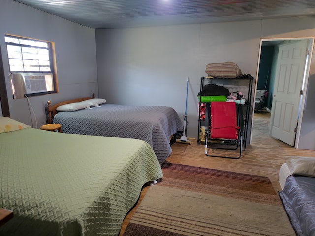 bedroom with cooling unit and wood-type flooring