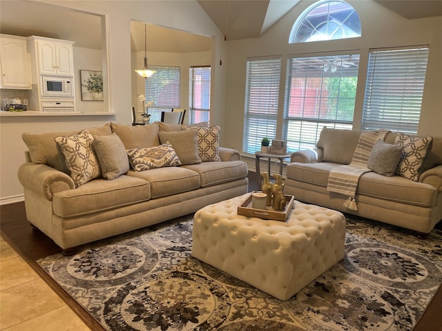 living room featuring vaulted ceiling and light tile patterned flooring