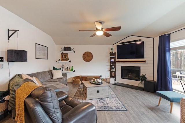 living room with vaulted ceiling, hardwood / wood-style floors, ceiling fan, and a fireplace